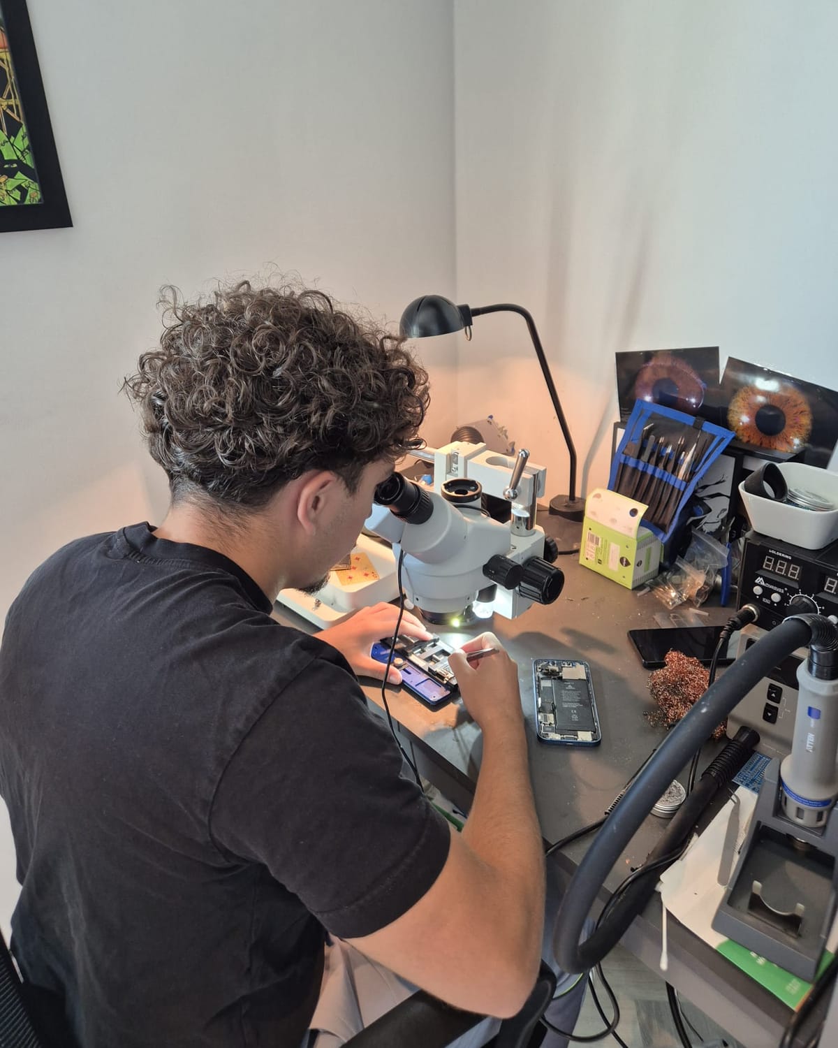 Technicus van QuickChip repareert een moederbord onder de microscoop in de werkplaats in Almere